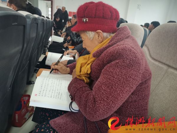 天元区长岭社区80岁“全国劳模”娭毑包光良在“新春第一课”上认真做笔记。